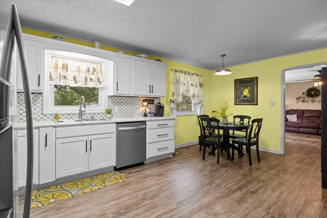 a kitchen with a dining table chairs and window