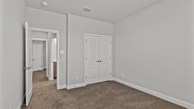a view of an empty room and kitchen view