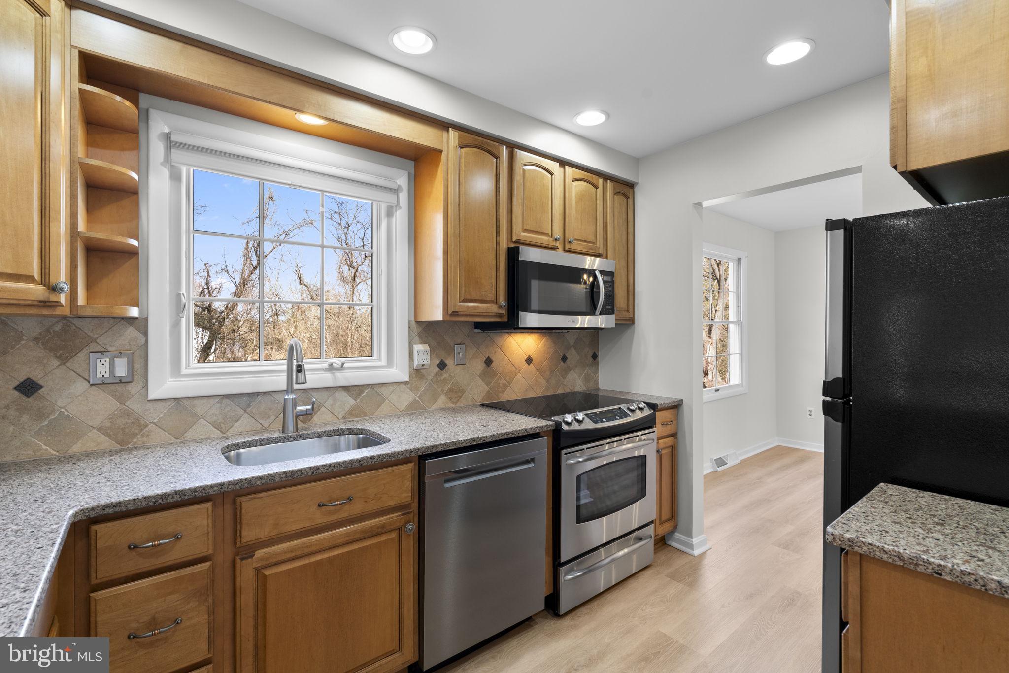 5461 Marsh Hawk Way Columbia, MD 21045 - Photo 12 of 48 a kitchen with stainless steel appliances granite countertop a sink stove and refrigerator