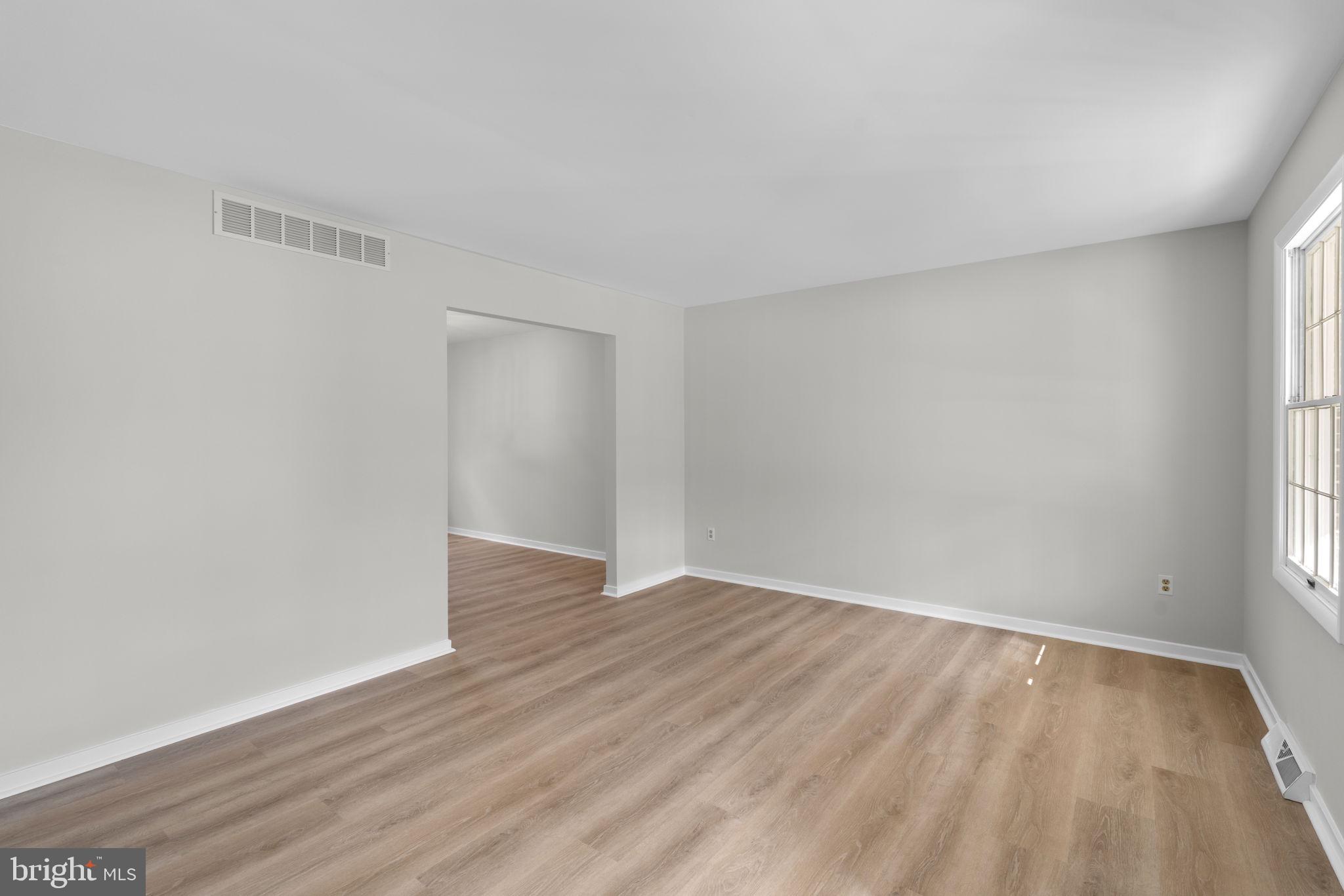 5461 Marsh Hawk Way Columbia, MD 21045 - Photo 5 of 48 a view of an empty room with wooden floor and a window