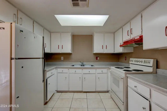 a kitchen with cabinets appliances and a sink