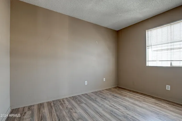 an empty room with wooden floor and a window