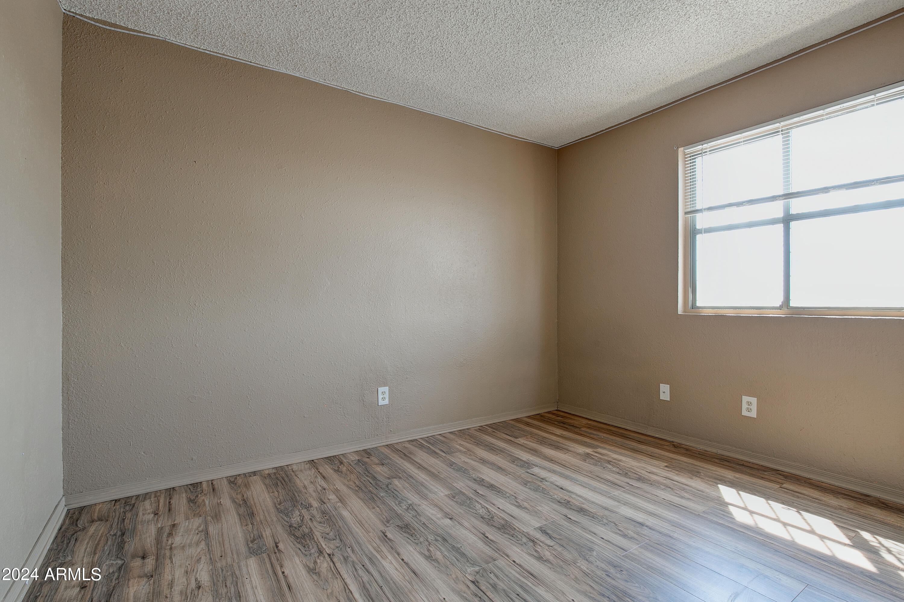 9631 North 12th Avenue, Unit 201 Phoenix, AZ 85021 - Photo 17 of 32 an empty room with wooden floor and windows