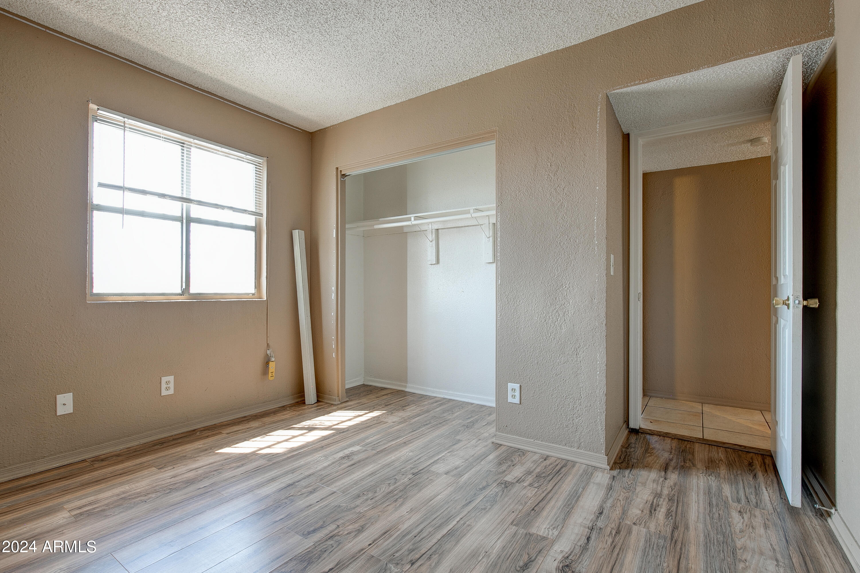 9631 North 12th Avenue, Unit 201 Phoenix, AZ 85021 - Photo 18 of 32 an empty room with wooden floor and windows