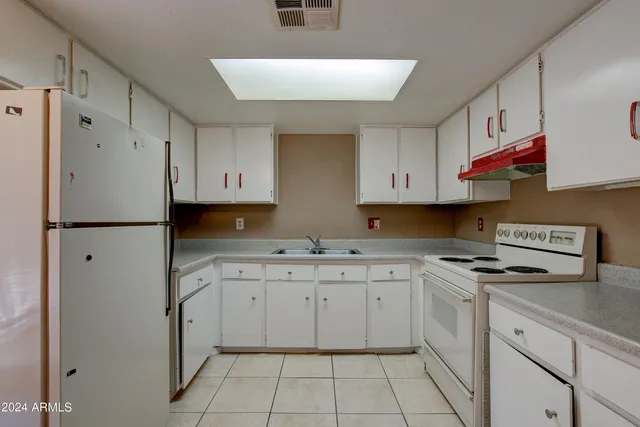 a kitchen with white cabinets stove top oven and sink
