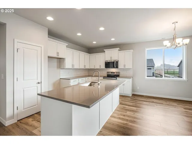 a kitchen with stainless steel appliances granite countertop a stove a sink and a microwave