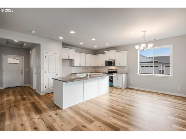 a kitchen with kitchen island sink stove and white cabinets