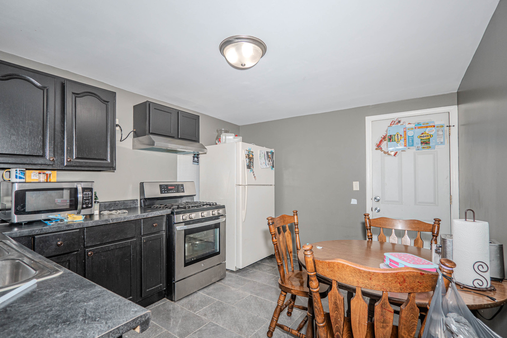 4910 West Walton Street Chicago, IL 60651 - Photo 23 of 27 a kitchen with stainless steel appliances granite countertop a stove a sink dishwasher and cabinets