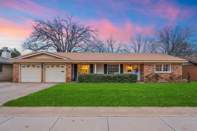 a front view of a house with a garden and yard