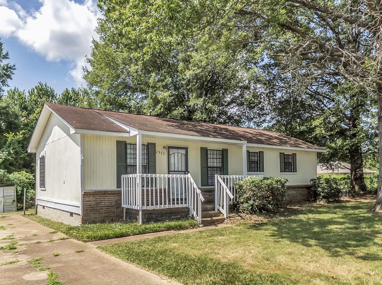 a view of a house with a yard and fence