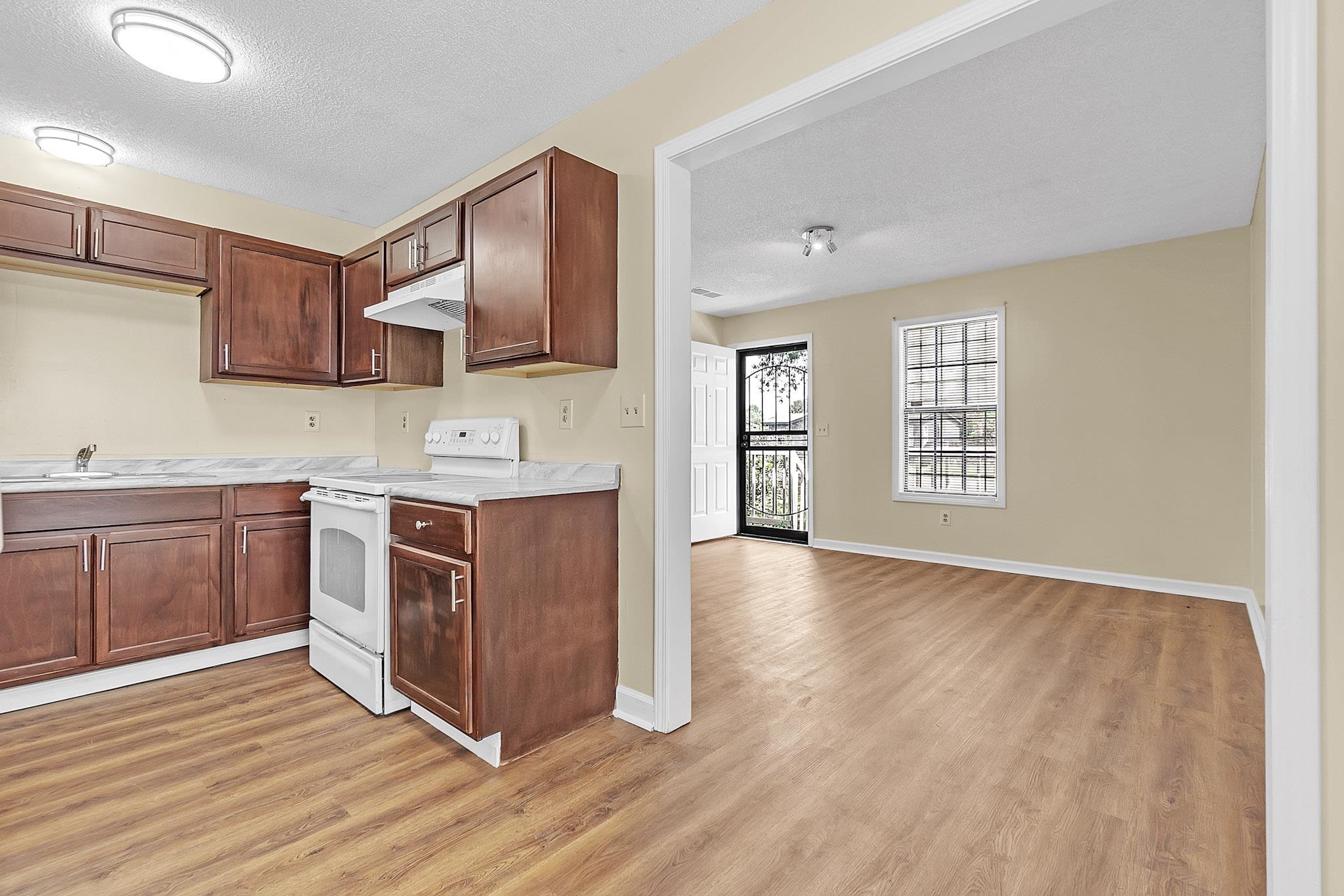 2955 Lake Park Road Memphis, TN 38127 - Photo 9 of 26 a kitchen with stainless steel appliances granite countertop a stove top oven a sink dishwasher and wooden cabinets with wooden floor