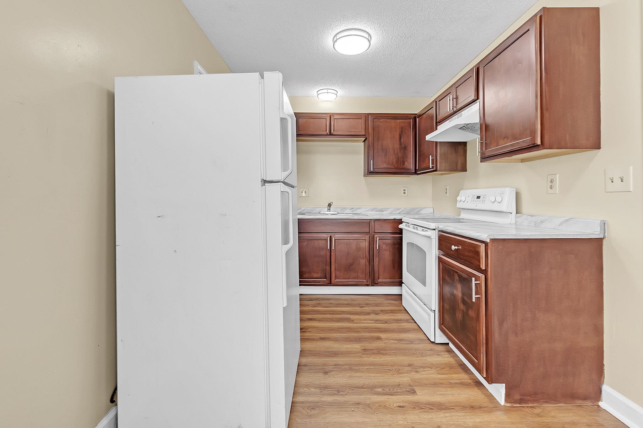 2955 Lake Park Road Memphis, TN 38127 - Photo 10 of 26 a kitchen with stainless steel appliances granite countertop a refrigerator a sink and a stove with wooden floors