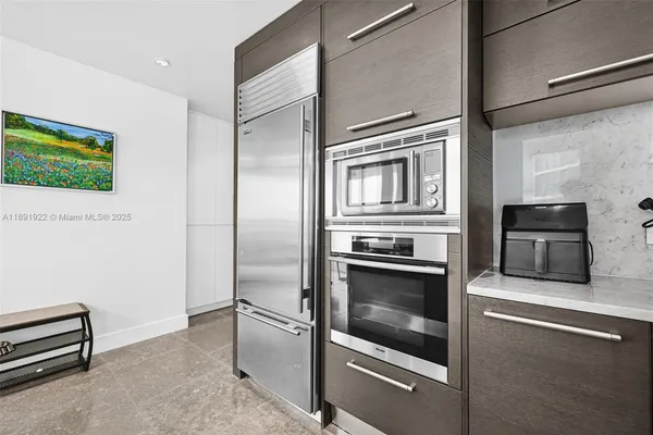 a kitchen with stainless steel appliances granite countertop a refrigerator and a stove