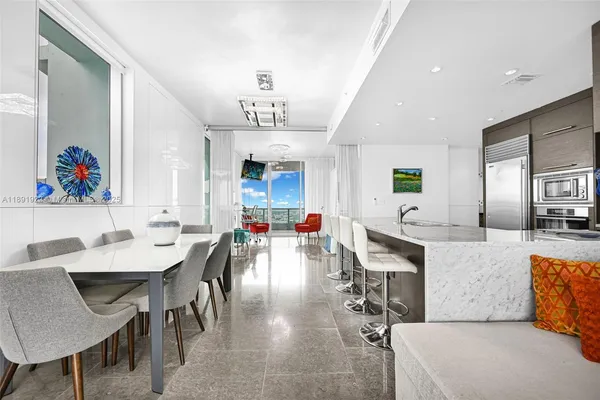 a living room with stainless steel appliances kitchen island granite countertop furniture and a kitchen view
