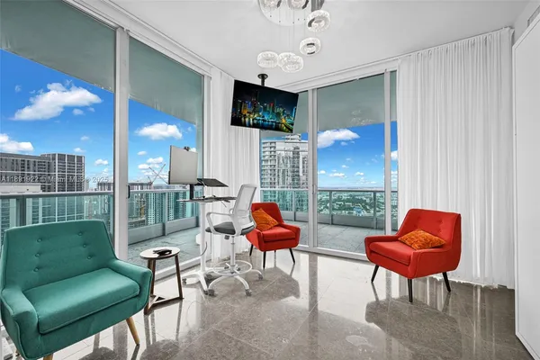 a living room with furniture a rug and a floor to ceiling window