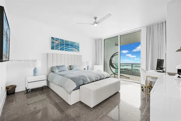 a bedroom with a bed a couch and a large window