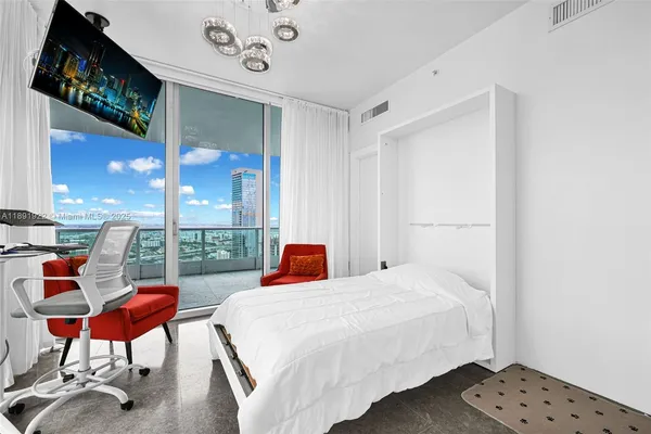 a bedroom with a bed a lamp and a large window