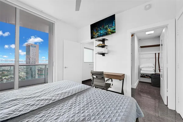 a bedroom with a bed and flat tv screen