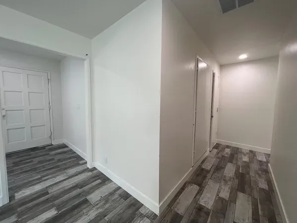 a view of a hallway with wooden floor and staircase