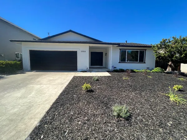 a front view of a house with a garden and yard