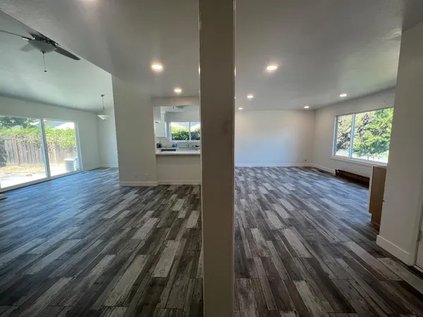 an empty room with wooden floor and windows