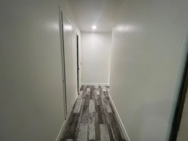 a view of a hallway with wooden floor
