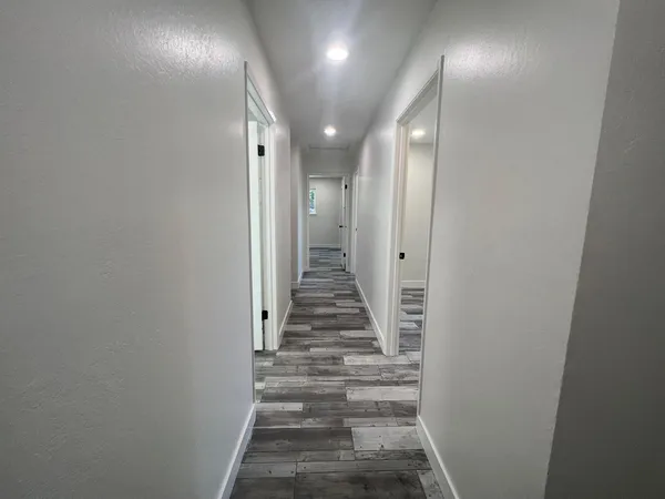 a view of a hallway with wooden floor and entryway