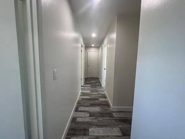 a view of a hallway with wooden floor and stairs