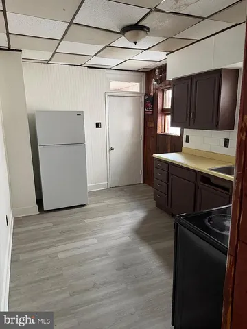 a view of an empty room with wooden floor and a garage