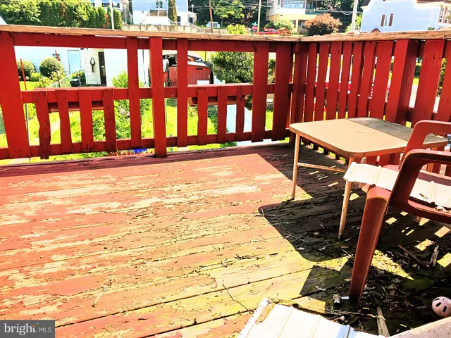 a view of a swimming pool with a patio and wooden fence