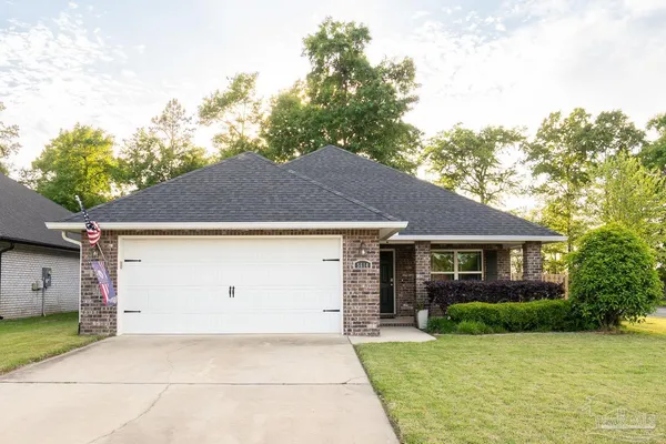 a front view of house with yard and trees around