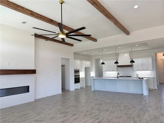 a view of a kitchen with a sink and wooden floor