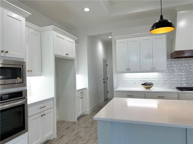 a kitchen with a sink a counter top space cabinets and stainless steel appliances