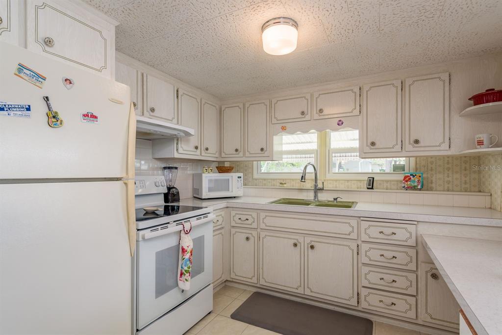 2331 Belleair Road, Unit 514 Clearwater, FL 33764 - Photo 7 of 39 a kitchen with granite countertop white cabinets and white appliances