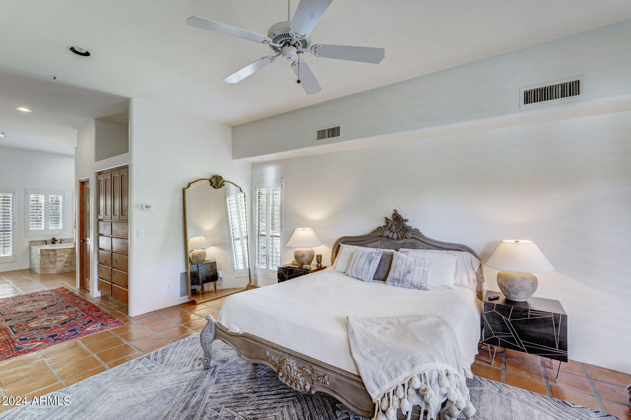 10468 East Quartz Rock Road Scottsdale, AZ 85255 - Photo 16 of 58 a bedroom with a bed and a chandelier