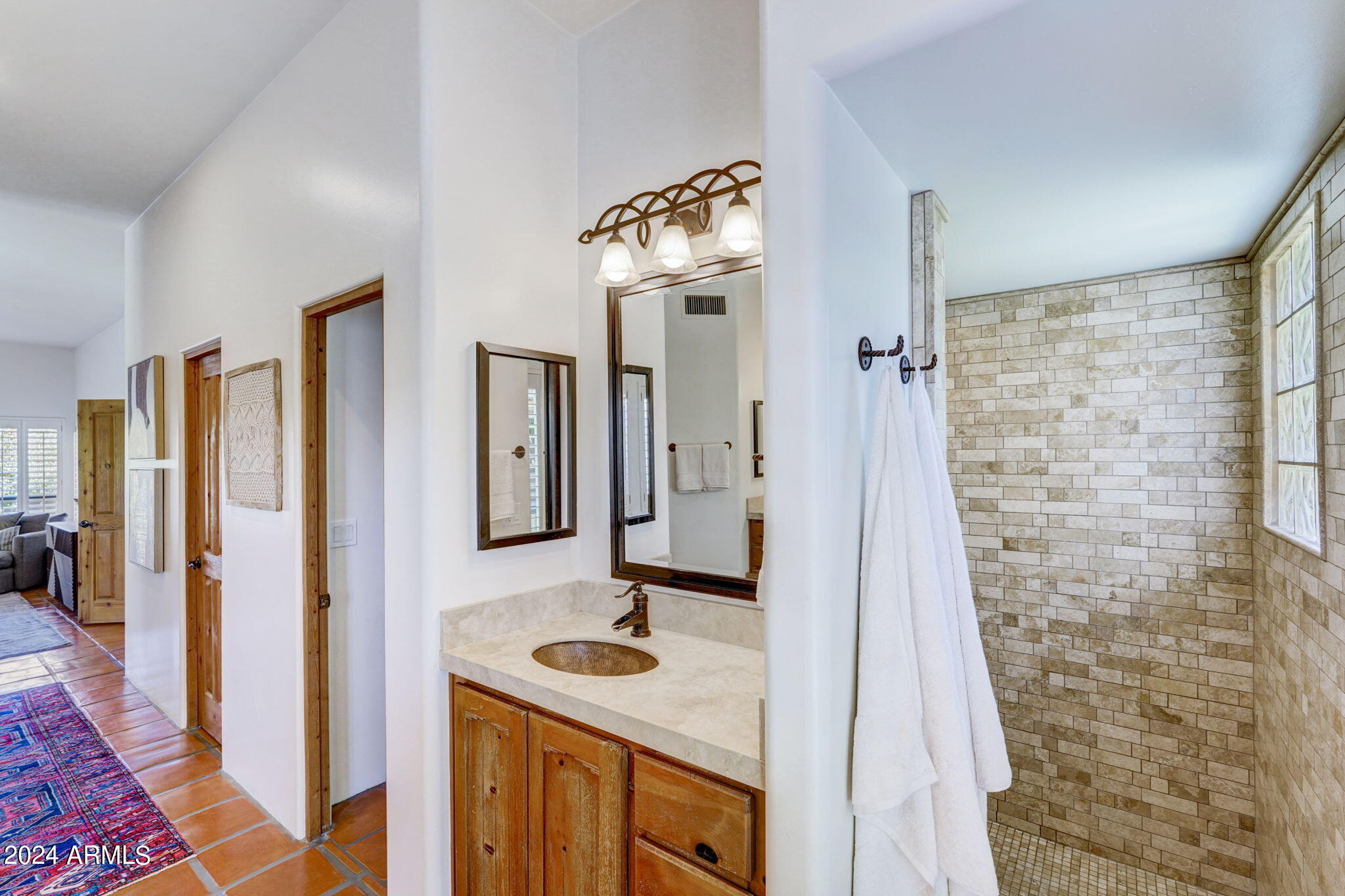 10468 East Quartz Rock Road Scottsdale, AZ 85255 - Photo 19 of 58 a bathroom with a sink a mirror and a shower