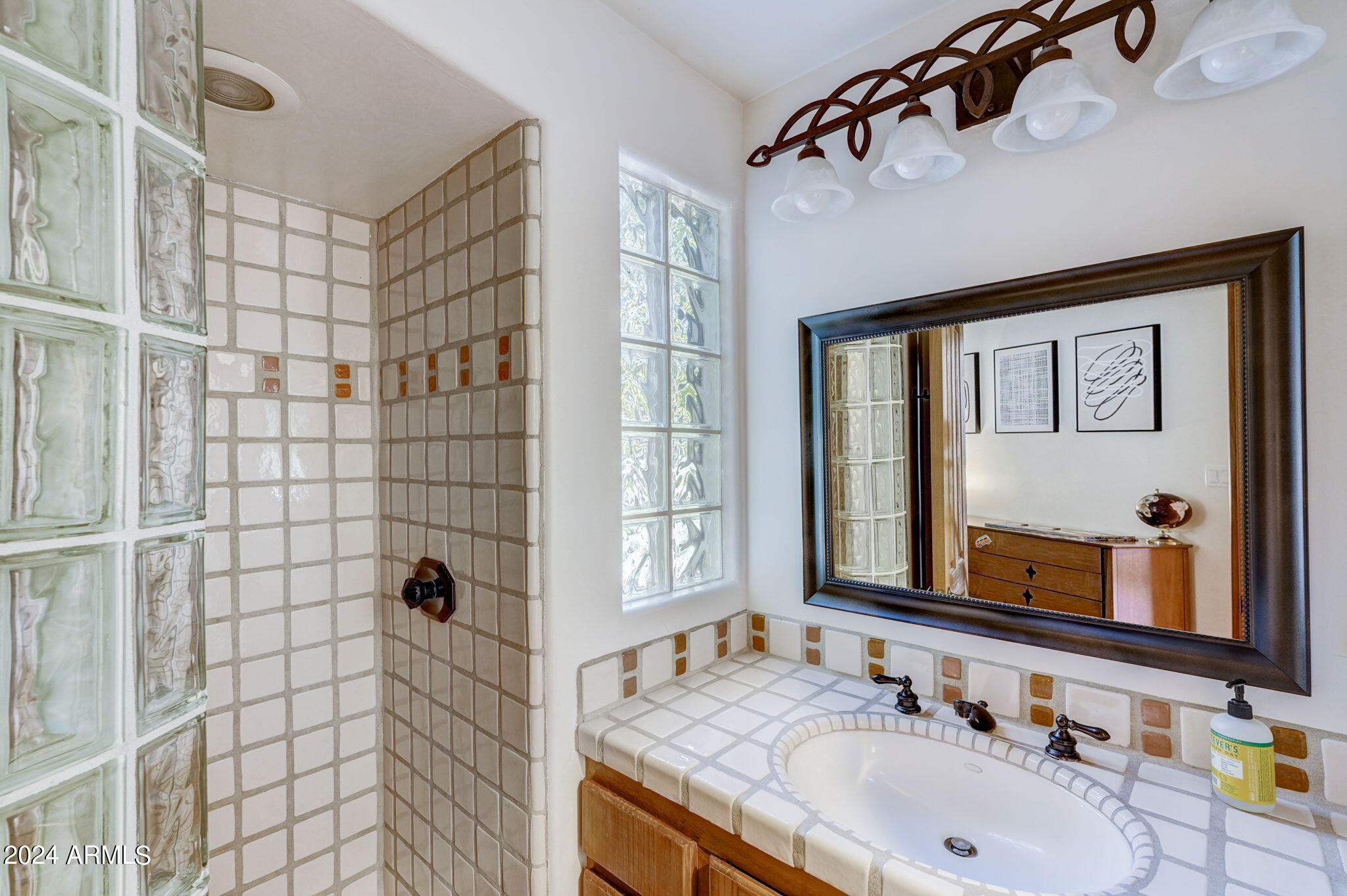 10468 East Quartz Rock Road Scottsdale, AZ 85255 - Photo 27 of 58 a bathroom with a granite countertop sink a mirror and shower
