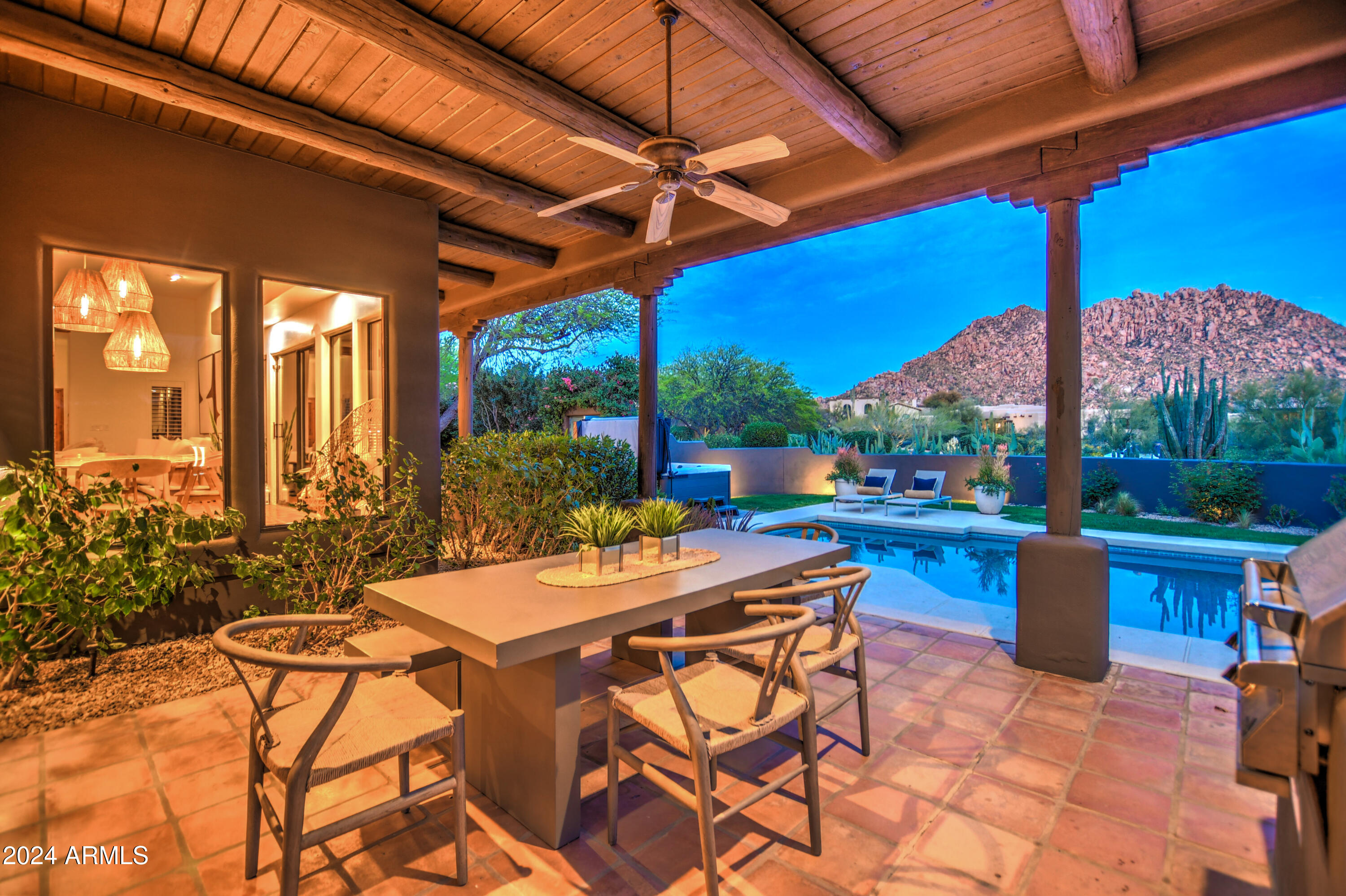 10468 East Quartz Rock Road Scottsdale, AZ 85255 - Photo 44 of 58 a view of a patio with a dining table and chairs under an umbrella
