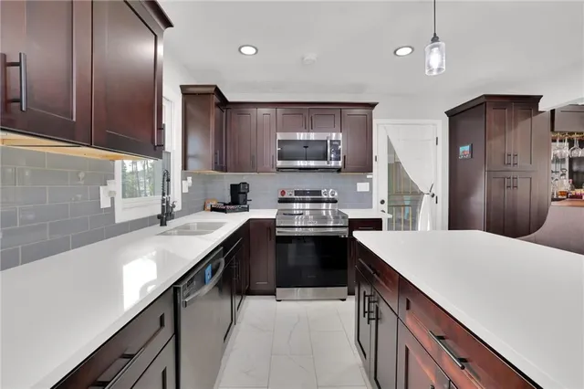 a kitchen with stainless steel appliances granite countertop a sink stove and refrigerator