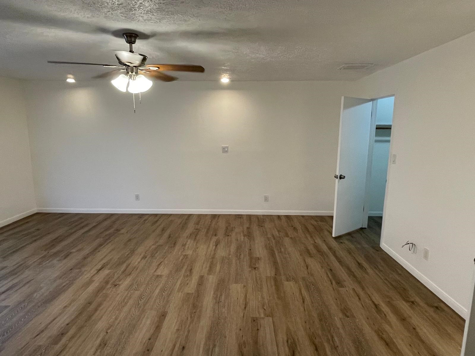 335 Carroll Road Richmond, TX 77469 - Photo 16 of 25 an empty room with wooden floor fan and window