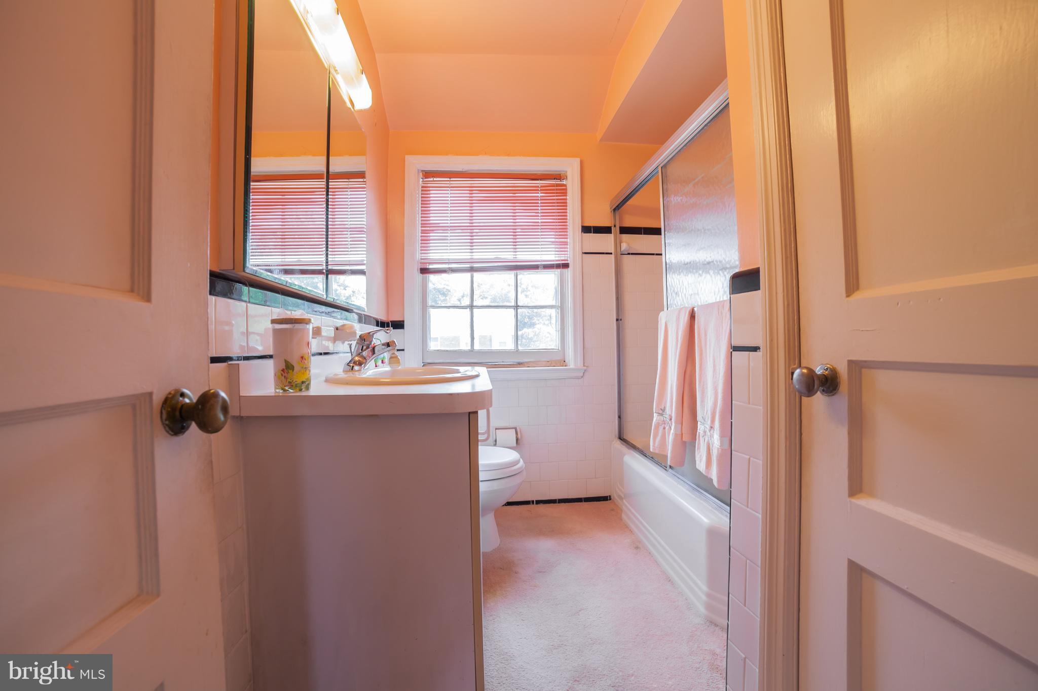 3908 Clarinth Road Baltimore, MD 21215 - Photo 14 of 23 a bathroom with a sink a mirror and a shower