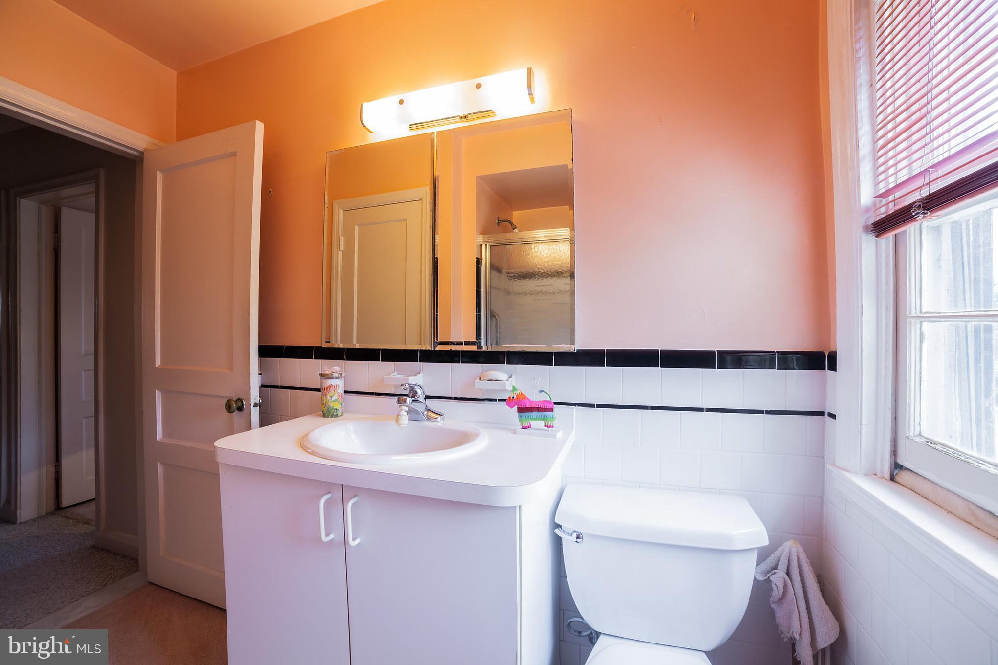 3908 Clarinth Road Baltimore, MD 21215 - Photo 15 of 23 a bathroom with a toilet a sink and a mirror