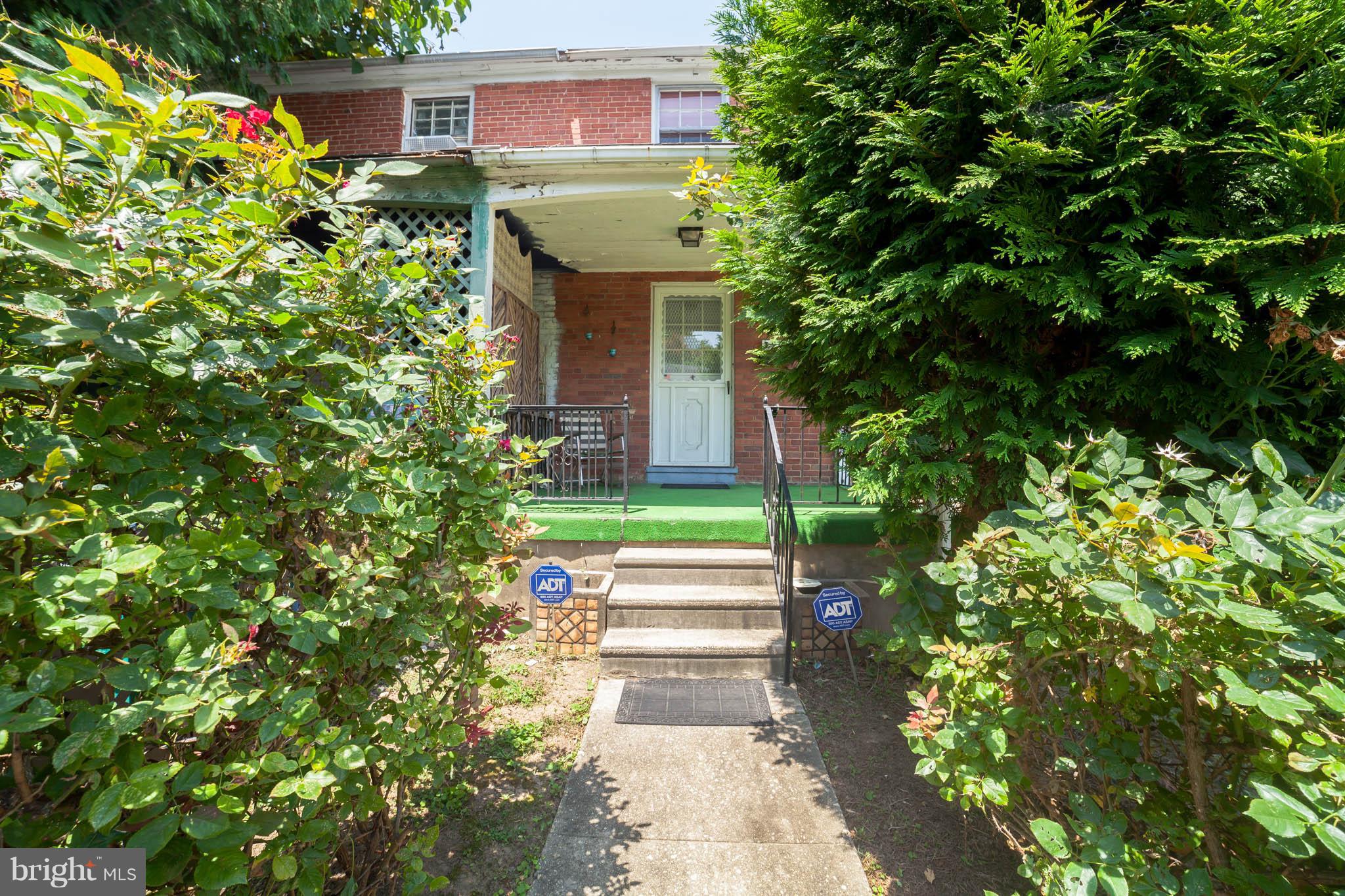 3908 Clarinth Road Baltimore, MD 21215 - Photo 3 of 23 a front view of a house with a yard and potted plants
