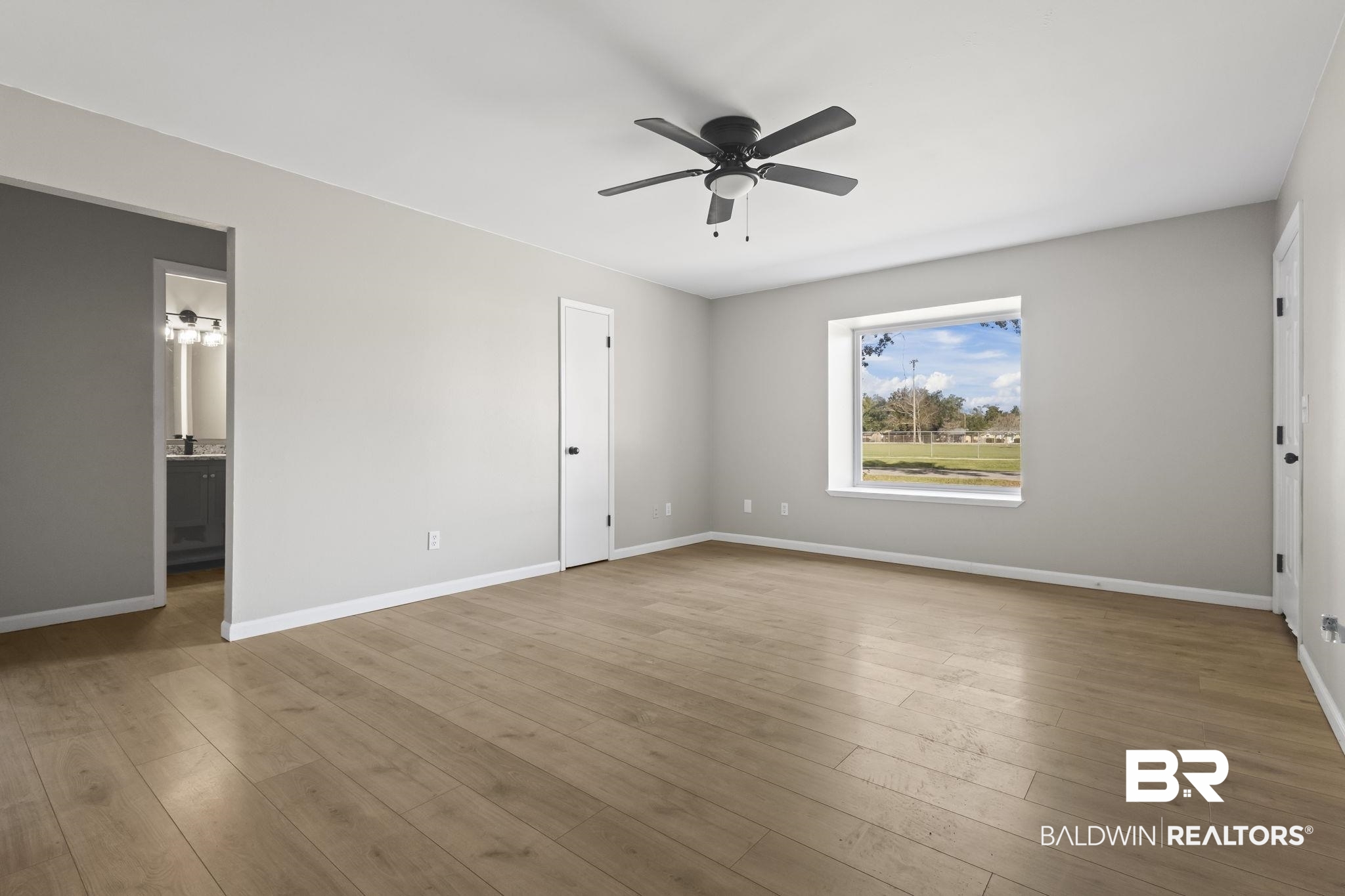 309 West Roosevelt Avenue Foley, AL 36535 - Photo 33 of 60 Unfurnished bedroom featuring ceiling fan, ensuite bathroom, and wood-type flooring