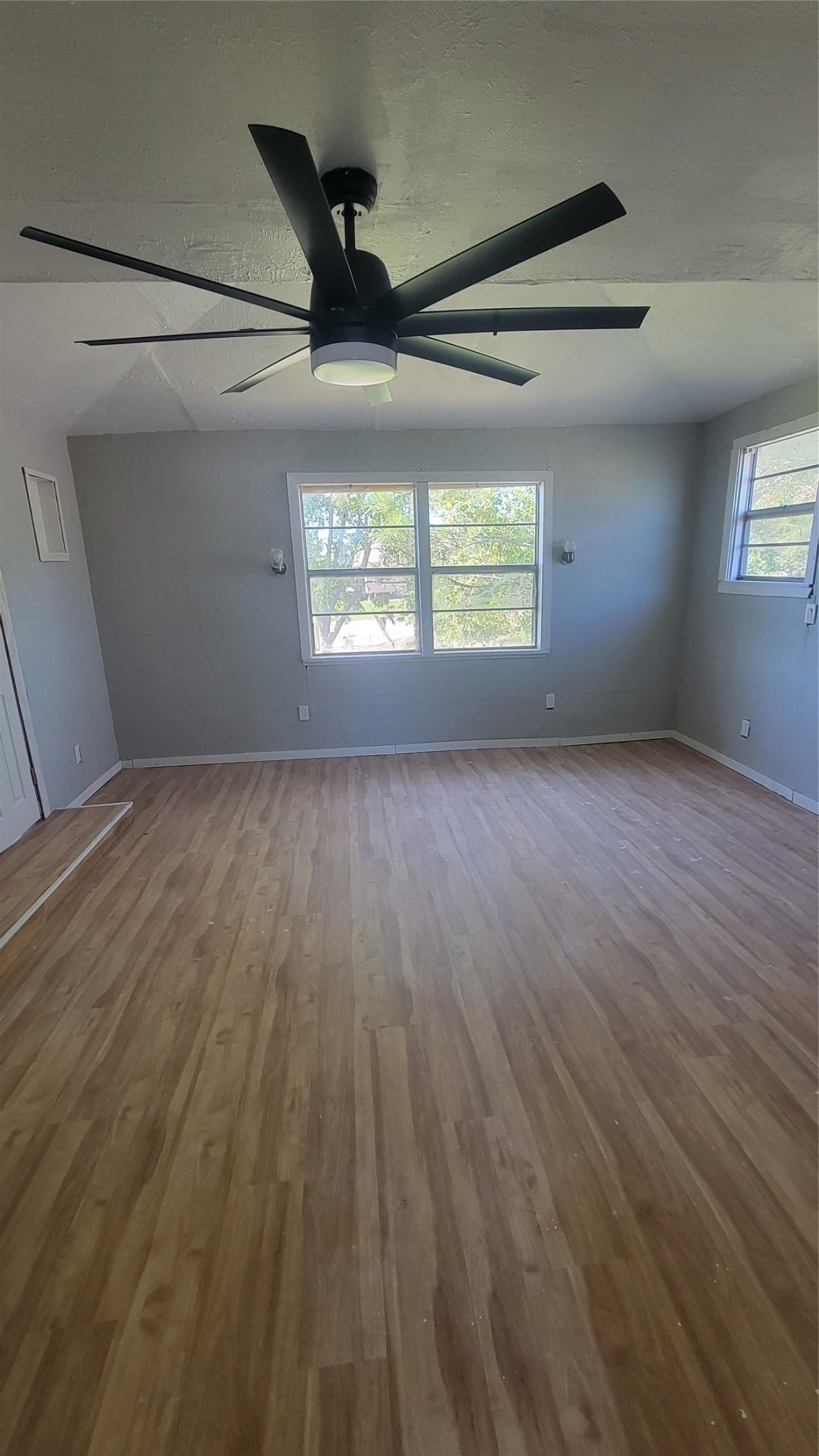 12018 Sandpiper Road Angleton, TX 77515 - Photo 17 of 48 an empty room with wooden floor ceiling fan and windows
