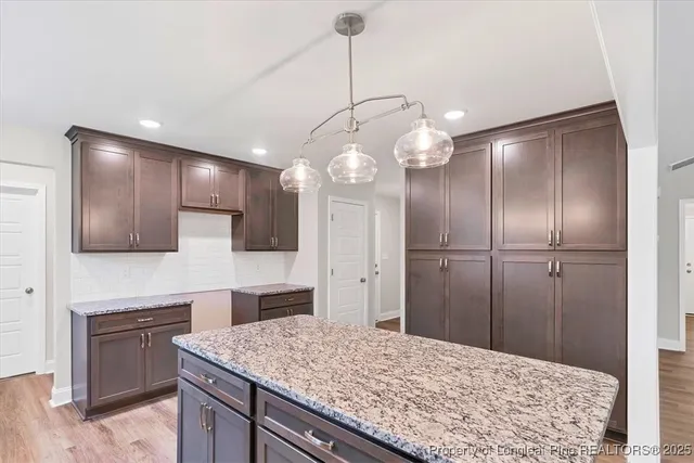 a kitchen with kitchen island granite countertop stainless steel appliances a stove refrigerator and microwave