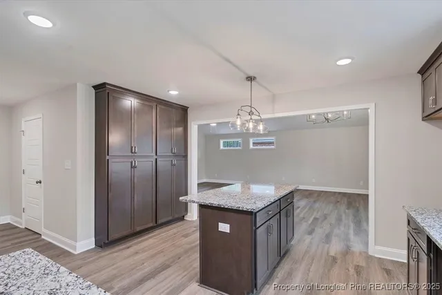 a kitchen with kitchen island granite countertop wooden cabinets and a sink