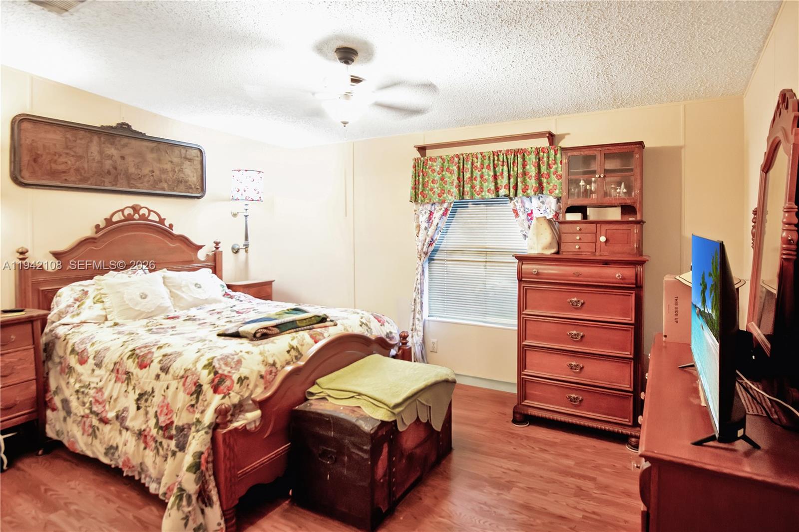 35250 Southwest 177th Court, Unit 48 Homestead, FL 33034 - Photo 11 of 29 a bedroom with a bed and a flat tv screen on dresser