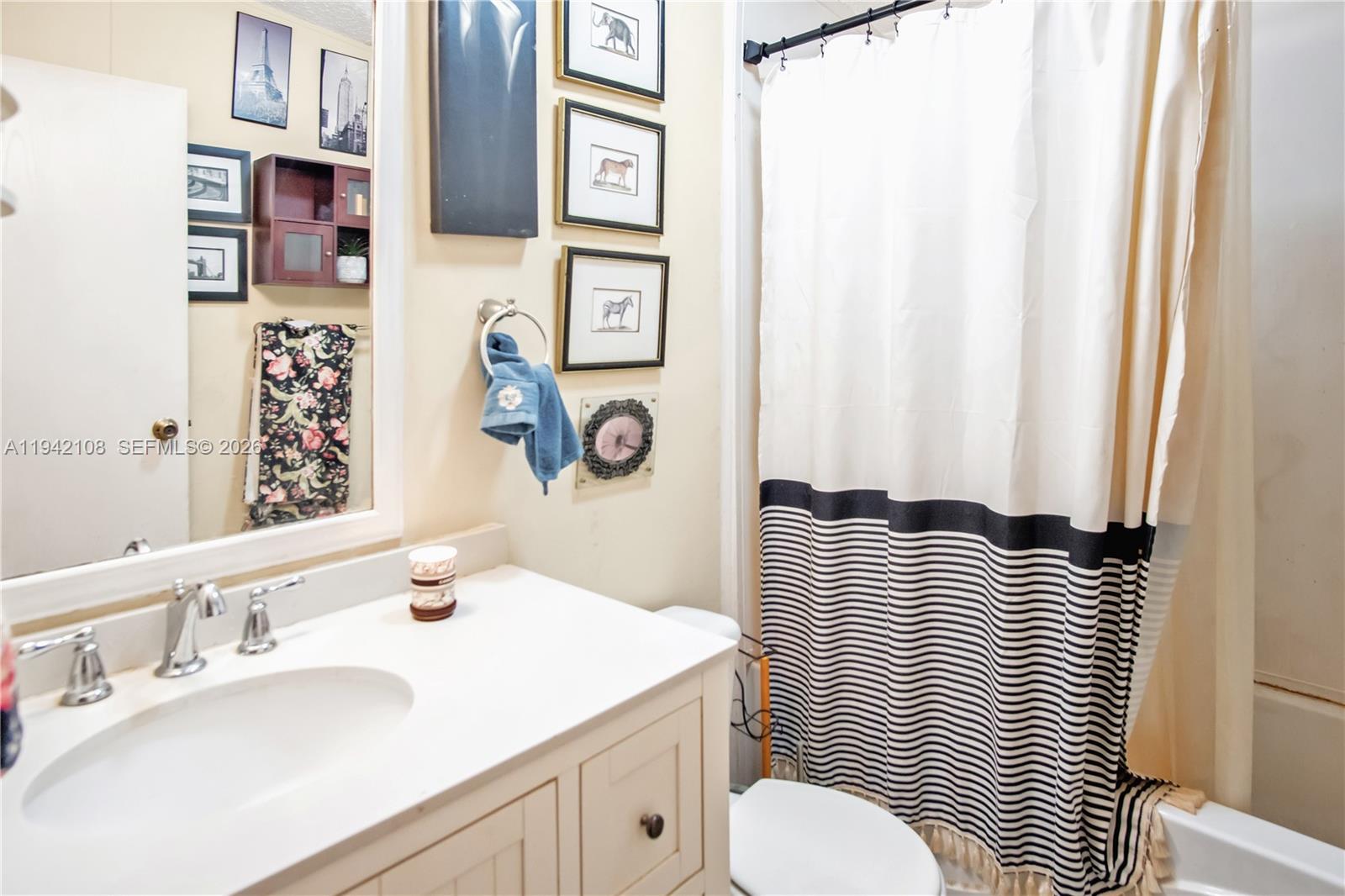 35250 Southwest 177th Court, Unit 48 Homestead, FL 33034 - Photo 16 of 29 a bathroom with a sink a toilet and shower curtain