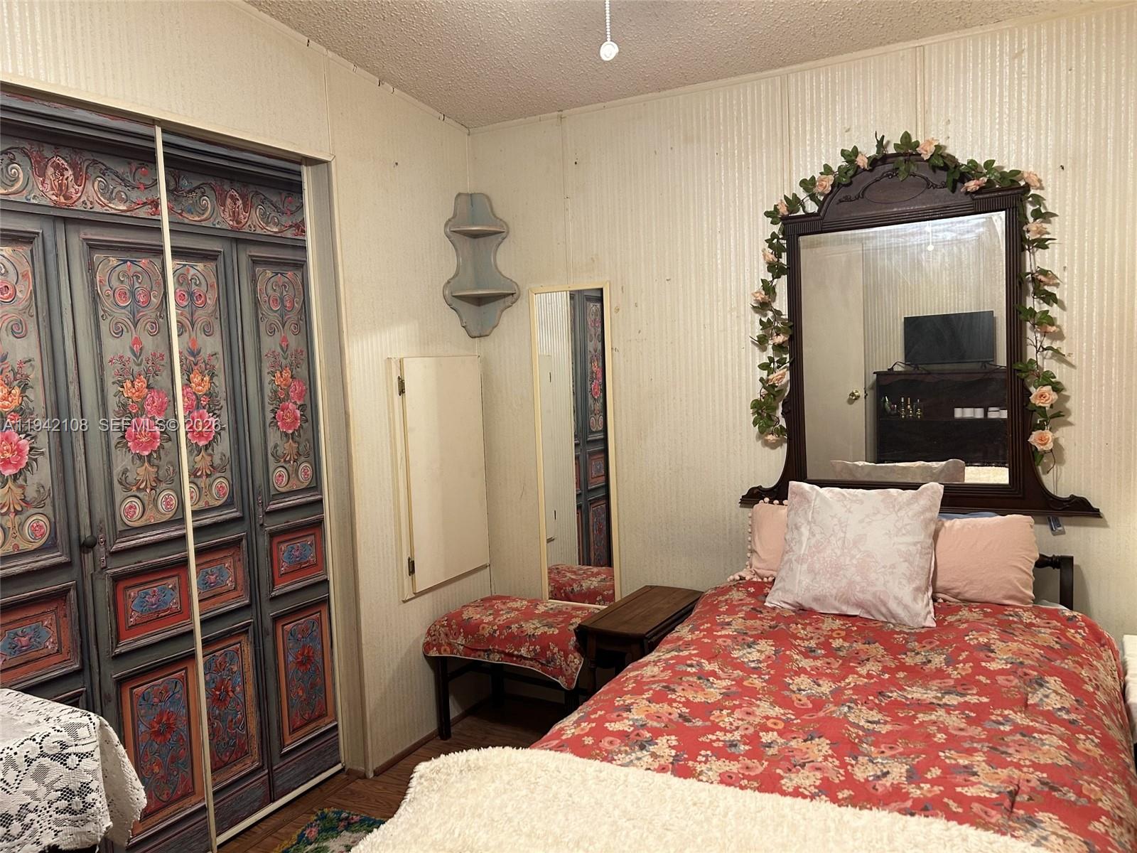 35250 Southwest 177th Court, Unit 48 Homestead, FL 33034 - Photo 19 of 29 a bedroom with a bed and wooden floor
